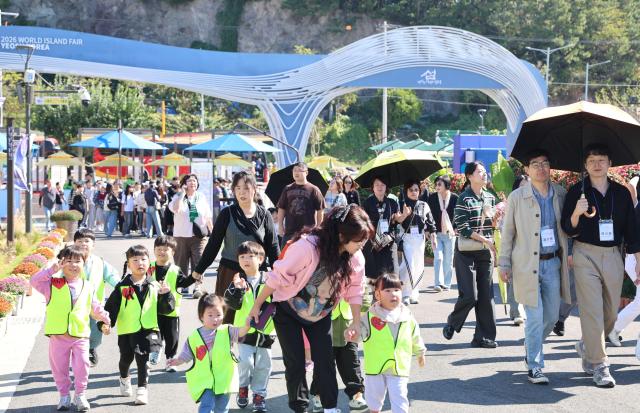 하루간의 시설 정비를 마치고 7일 재개장한 2026여수세계섬박람회 돌산 진모지구 주행사장에 가족 단위 관람객들이 줄지어 입장하고 있다 조직위는 국제교류섬 전시를 17개 국가·지방정부로 교체하고 가을꽃과 야간 조명 체험·편의시설 등을 새롭게 보강했다2026여수세계섬박람회 조직위원회
