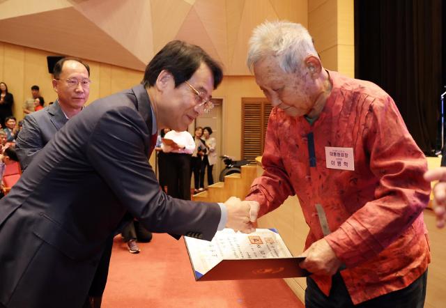 강진원 강진군수가 지난 7일 강진아트홀에서 열린 ‘제30회 노인의 날 기념행사’에서 대통령 표창을 받은 이병학 어르신에게 표창장을 대신 전달한 뒤 악수를 나누고 있다 이 어르신은 지역사회와 노인복지 발전에 기여한 공로를 인정받아 대통령 표창을 받았다사진강진군