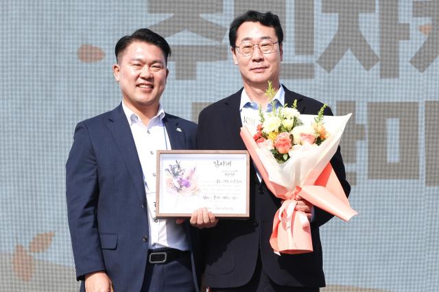 정명근 화성특례시장오른쪽이 ‘2026년 주민자치 소통 한마당’에서 감사패를 받고 기념촬영을 하고 있다 사진화성시