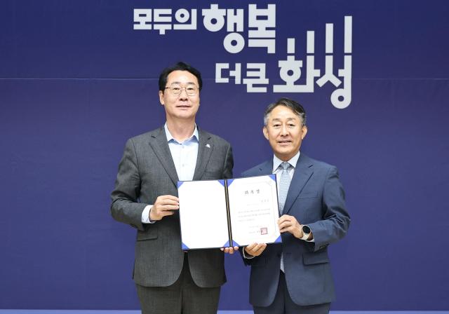 정명근 화성특례시장왼쪽이 양성일 화성형 기본사회위원회 위원장오른쪽에게 위촉장을 수여한 뒤 기념촬영을 하고 있다 사진화성시