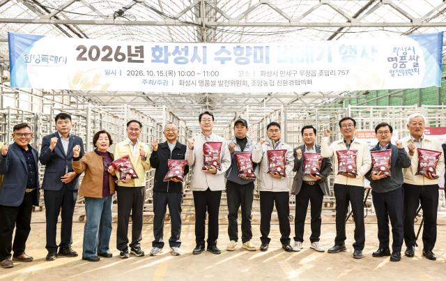 정명근 화성특례시장이 수향미 벼베기 행사 참석자들과 수향미를 들고 기념촬영을 하고 있다 사진화성시
