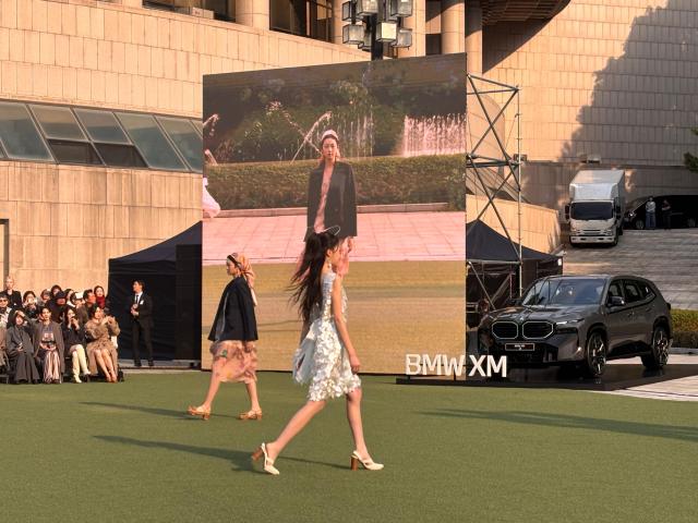 Models walk the runway during Miss Gee Collections 2027 springsummer fashion show at the Seoul Arts Center in southern Seoul on Oct 15 2026 with a BMW XM on display beside the stage AJP Ryu Yuna