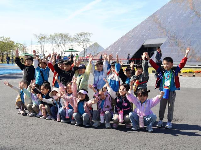지난 15일 2026여수세계섬박람회 주행사장을 찾은 어린이들이 전시관 앞에서 두 손을 높이 들고 환하게 웃으며 기념촬영을 하고 있다 이날 박람회장에서는 ‘2026 여수시민의 날’ 기념행사가 열려 시민과 관람객 5000여 명이 다채로운 공연과 체험 프로그램을 즐겼다 사진2026여수세계섬박람회 조직위원회