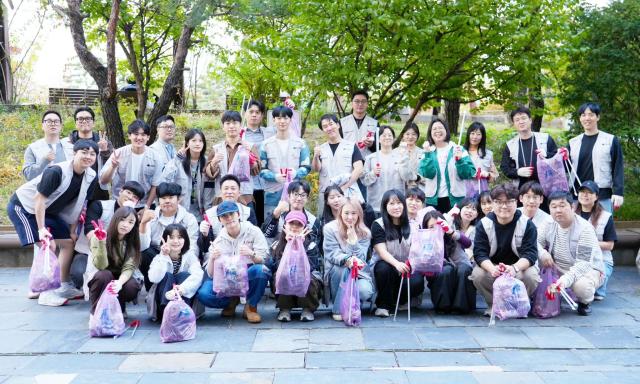 1 토스인슈어런스 임직원들이 15일 서울 구로구 신도림역 인근 도림천 일대에서 지역 상생・포용 금융을 위한 임직원 플로깅Plogging 활동을 마친 후 기념사진을 촬영하고 있다