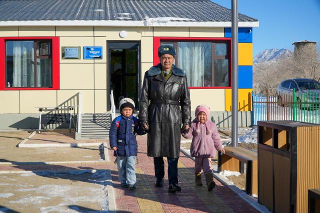 A parent accompanies two children to a newly established primary school at a border guard unit in Mongolia in 2025 Courtesy of UNICEF Mongolia