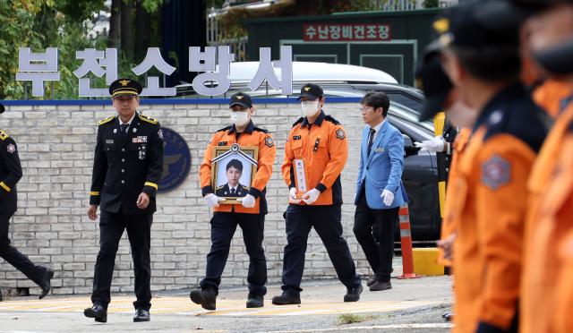 19일 경기도 부천 원미구 부천체육관에서 열린 고 김진석 소방위 영결식 뒤 영정과 위패를 든 소방관들이 부천소방서에 도착하고 있다 사진연합뉴스