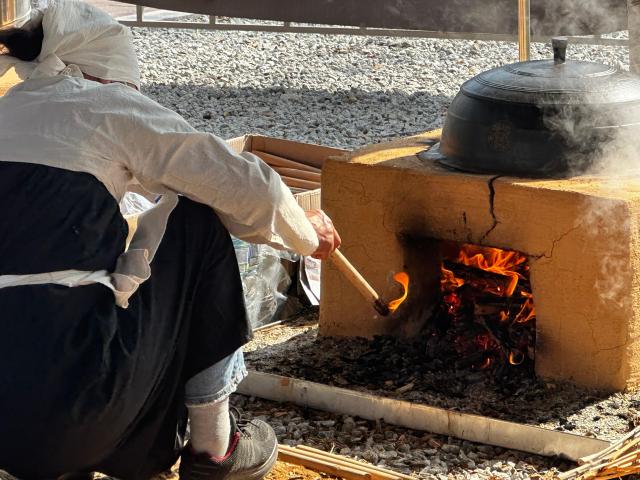 A woman tends a wood fire beneath a traditional Korean iron cauldron known as gamasot while cooking rice at the Icheon Rice Cultural Festival in Icheon Gyeonggi Province on Oct 15 2026 AJP Kim Hee-su