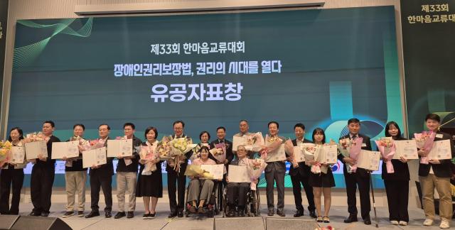 20일 전남 여수 베네치아 호텔에서 열린 ‘제33회 전국 장애인 한마음교류대회’에서 장애인 복지 증진과 권익 보호에 기여한 유공자들이 표창을 받은 뒤 꽃다발과 표창장을 들고 기념촬영을 하고 있다 전국 장애인단체 관계자 500여 명이 참여한 이번 대회는 장애인 권리보장과 사회참여 확대를 위한 정책 논의 및 교류의 장으로 마련됐다 사진전남광주통합특별시