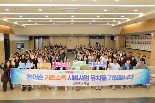 지난 19일 전남 해남군청 2층 대회의실에서 열린 ‘기본사회·농어촌 기본소득 특별강연회’에서 공직자와 지역주민 등 참석자들이 ‘2027년 농어촌 기본소득 시범사업’ 유치를 기원하며 구호를 외치고 있다 해남군은 이번 강연회를 계기로 군민 공감대를 확대하고 사업 선정을 위한 준비에 행정력을 집중할 방침이다 사진해남군