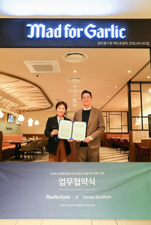 지난 22일 매드포갈릭 건대스타시티점에서 윤다예 엠에프지코리아 대표왼쪽와 배익렬 스트레스솔루션 대표가 스트레스 완화형 힐링 다이닝 조성을 위한 업무협약MOU을 체결하고 기념촬영을 하고 있는 모습 사진엠에프지코리아