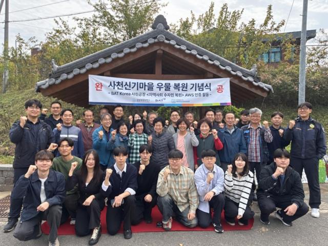 BAT 사천공장과 경상국립대학교 연구팀 마을 주민들이 23일 사천시 신기마을에서 열린 우물 복원 기념식에서 기념촬영을 하고 있다 사진BAT코리아제조