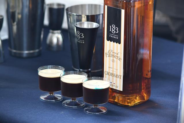 Tasting drinks sit beside a bottle of 1883 Maison Routin croissant-flavored syrup at Food Experience Korea in Seoul Oct 26 2026 AJP Joonha Yoo
