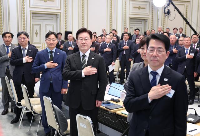 이재명 대통령이 26일 청와대에서 열린 농어민과의 대화 행사에서 국기에 경례를 하고 있다 사진연합뉴스