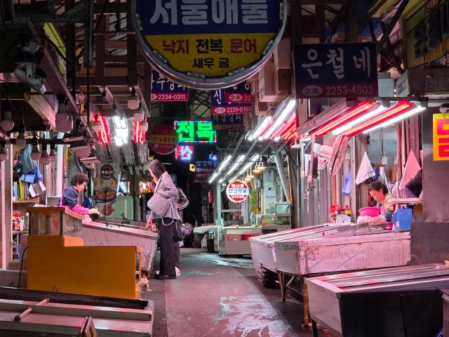 서울 중구 신당 중앙시장 골목. 한 시민이 정육점에서 고기를 고르고 있다. [사진=정연우기자]