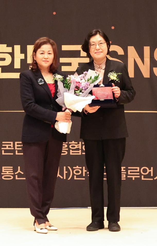 지난 26일 서울 한국프레스센터에서 열린 ‘2026 대한민국 SNS 대상’ 시상식에서 기초지자체 군 부문 최우수상을 수상한 강진군 4차산업혁명활용추진단 방현정 단장오른쪽이 주최 측 관계자로부터 상패와 꽃다발을 전달받고 기념촬영을 하고 있다 강진군은 공무원이 직접 개발한 ‘강진프렌즈’ 캐릭터와 자체 제작 SNS 콘텐츠를 활용한 군정·관광 홍보 성과를 인정받았다 사진강진군