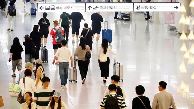 抵达济州国际机场的游客走出航站楼 【图片来源 韩联社】