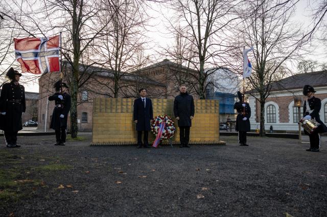 Norwegian Defense Minister Tore O Sandvik right and South Korean Defense Minister Ahn Gyu-back stand beside a wreath laid in memory of those who died during the Korean War at Akershus Fortress in Oslo Norway on Nov 28 2025 Courtesy of Synne Kvam  Norwegian Ministry of Defence