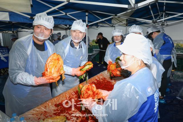 Voluntarios posan con kimchi en actividad de elaboración y distribución en centro de bienestar para adultos mayores