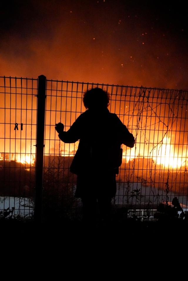 Villager at Guryong Village looks over the fire destroying her village in front of her eyes Courtesy of CHOI Yohan