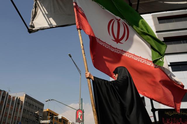 Mujer portando la bandera de Irán durante una campaña a favor del gobierno en el centro de Teherán. [Foto=AP·Yonhapnews]