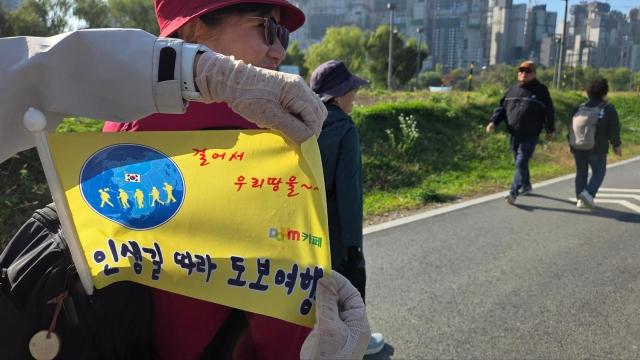 이씨는 가방에 인생길따라 도보여행이라는 문구가 적힌 노란 깃발도 달고 나왔다 사진김지윤 기자